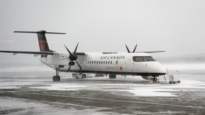Un avion Bombardier Q 400 d'Air Canada Express sur le tarmac en hiver.