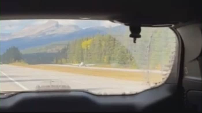 Capture d'une vidéo montrant un petit avion le long de l'autoroute 1A dans les Rocheuses entre Lake Louise et Banff.