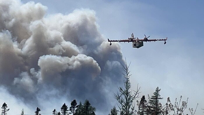Un avion-citerne survole le feu près du lac Barrington dans le sud de la Nouvelle-Écosse.