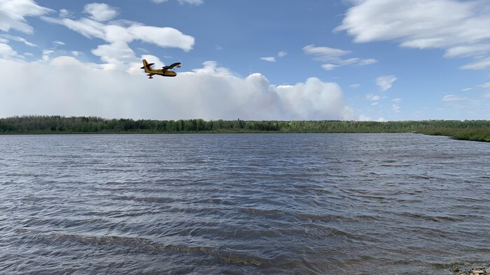 Un avion-citerne vole au-dessus d'un lac.