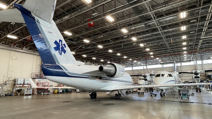 Trois avions garés dans un hangar.