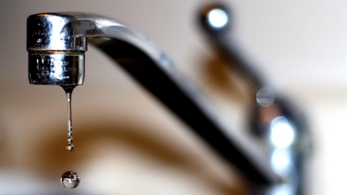 une goutte d'eau tombe d'un robinet