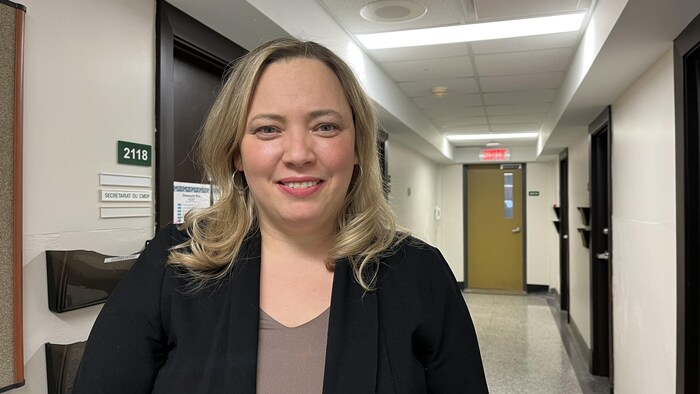 Audrey Bergeron se trouve dans un couloir et sourit à la caméra.