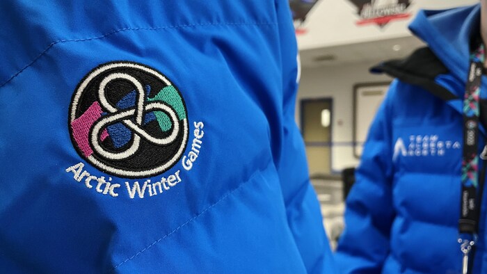 Logo des Jeux d'hiver de l'Arctique brodé sur un manteau.