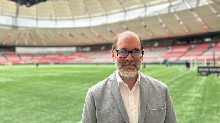 Un homme se tient debout dans un stade. 