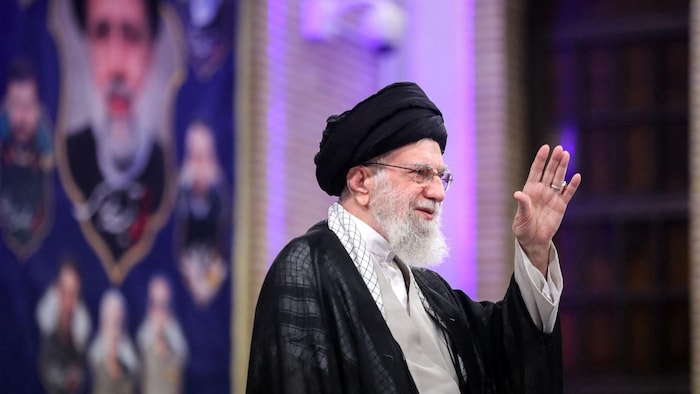 L'ayatollah Ali Khamenei fait un salut avec sa main.