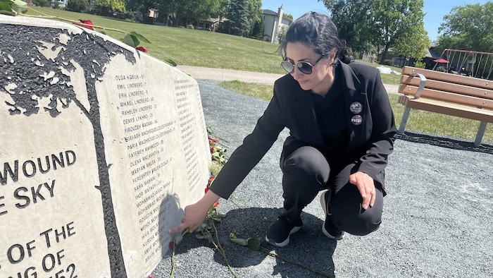 Azadeh Heidaripour touche le nom de son fils, Amir Morandi, sur le monument dévoilé en son honneur et des autres victimes, le 5 juillet 2025.