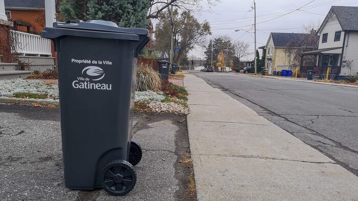 Un bac placé près du trottoir pour la collecte des déchets.