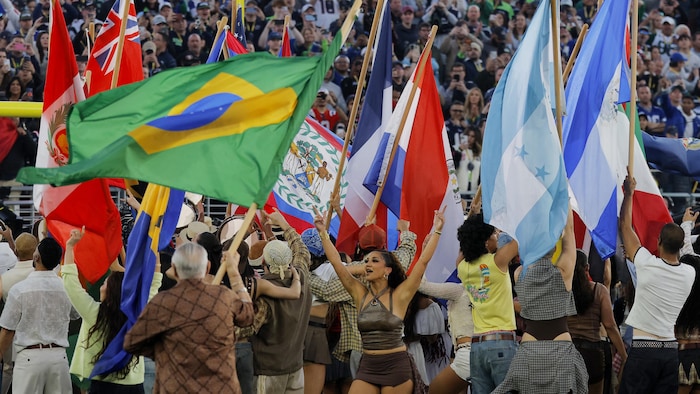 Une foule de personnes brandit des drapeaux d'États américains.