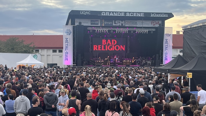 Une foule massée devant une scène de spectacle.
