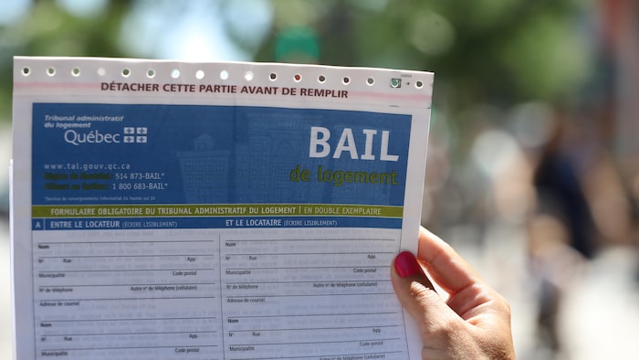Une main tient un bail non rempli, avec le logo du Tribunal administratif du logement.