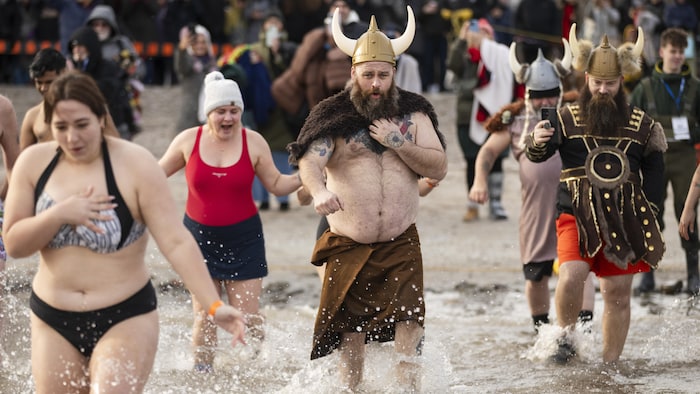 Des gens participent au bain du Nouvel An à Oakville en Ontario, le mercredi 1er janvier 2025.