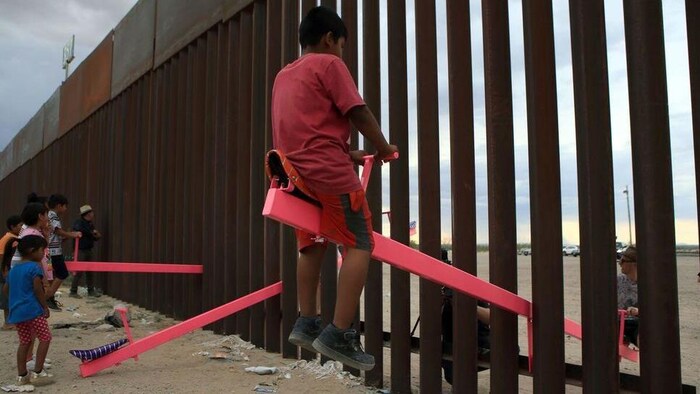 Des balançoires installées entre les barreaux du mur qui sépare les États-Unis du Mexique.