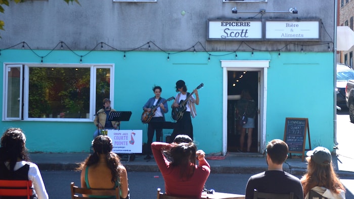 Un trio musical jouant sur le trottoir.