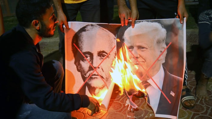Un homme brûle les portraits de Lord Balfour et de Donald Trump.
