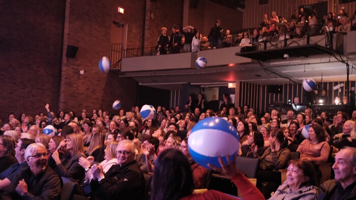 Des ballons gonflables se balancent dans une foule.