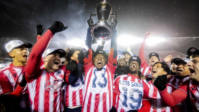 Ballou Tabla soulève le trophée près de ses coéquipiers euphoriques.
