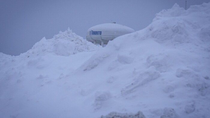 Le château d'eau de Warden est visible derrière une montagne de neige, à Scarborough, le 16 janvier 2026.