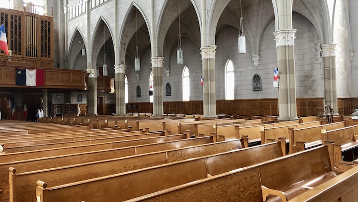 Des rangées de bancs de bois dans l'église.