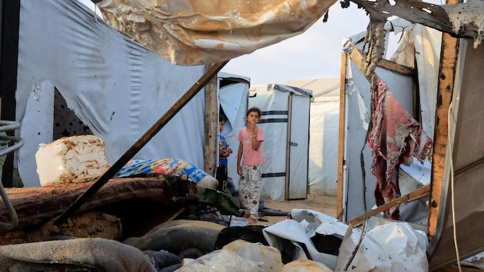 Deux enfants parmi les décombres regardent autour d'eux.