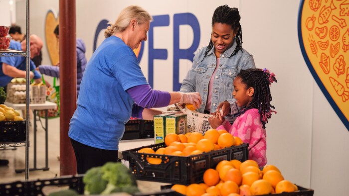 Une mère et sa fille reçoivent des aliments frais à la Banque alimentaire.