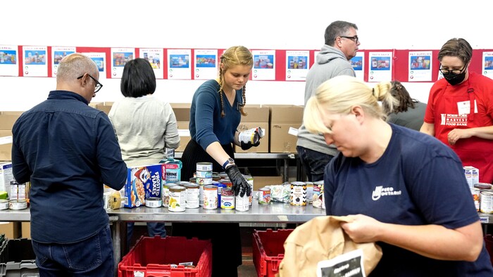 Des bénévoles travaillent dans une banque alimentaire.