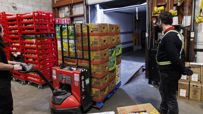 Des palettes de denrées alimentaires sont chargées dans un camion,