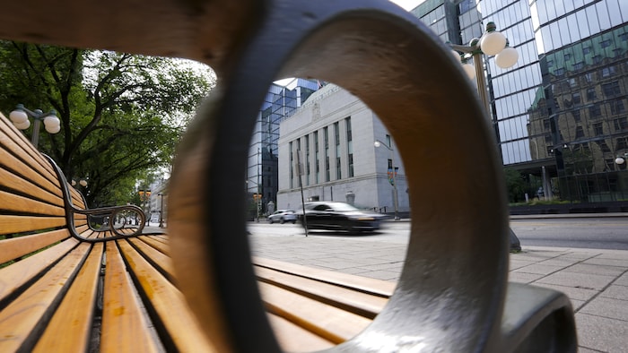 La Banque du Canada, vu à travers l'appui-bras d'un banc public.
