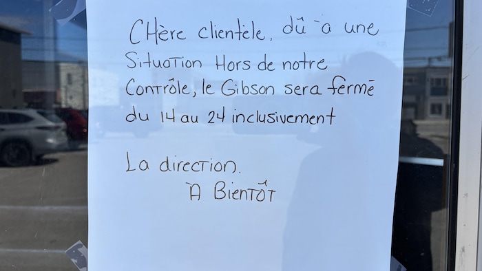 Une affiche indiquant la fermeture d'un bar est collée à une fenêtre.