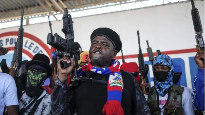 جيمي ’’باربيكيو‘‘ شيريزييه (وسط الصورة)، أحد قادة العصابات المسلحة في هايتي، وهو ضابط شرطة سابق، محاطاً ببعض رجاله المسلحين.