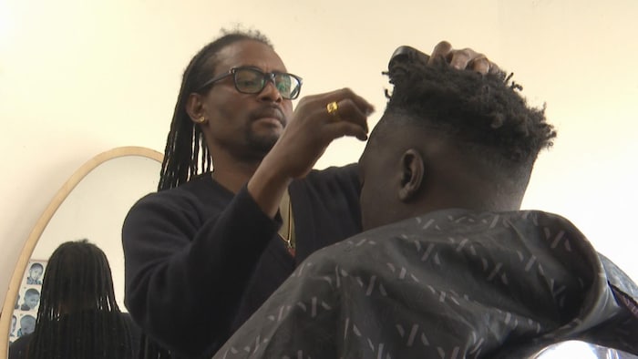 Un coiffeur qui coiffe.