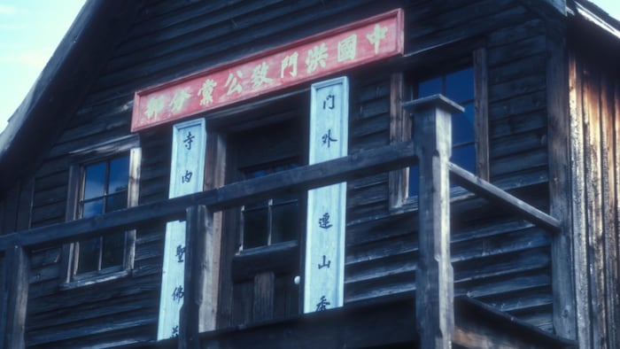 Un bâtiment en bois avec des insignes en chinois dessus.