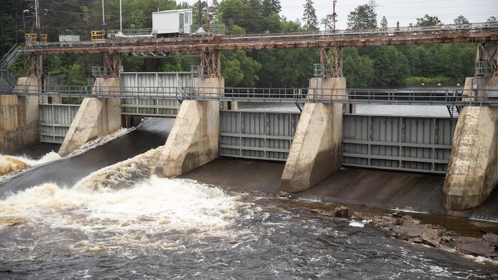 Une vanne d'évacuation d'un barrage hydroélectrique est ouverte.