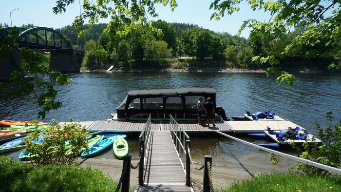 Un ponton sur une rivière entouré de kayak en location près d'un quai.