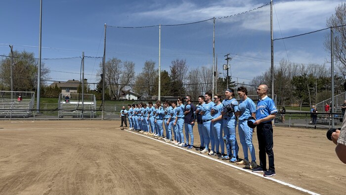 Des joueurs de baseball debout durant l'hymne nationale.