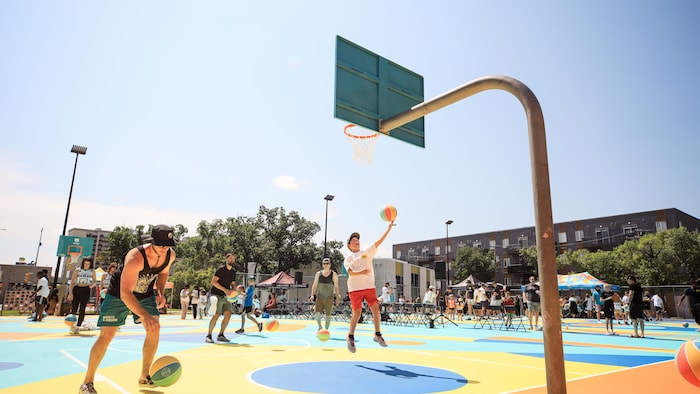 Des enfants jouent au basketball, lors de l'inauguration officielle de nouveaux terrains.