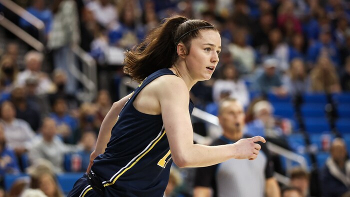 Une basketteuse court sur le terrain.