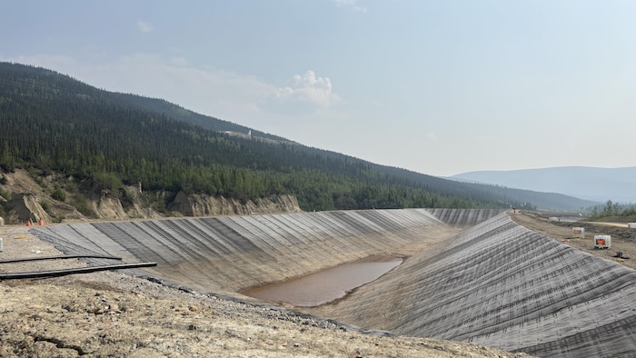 Un bassin à ciel ouvert au pied d'une montagne.