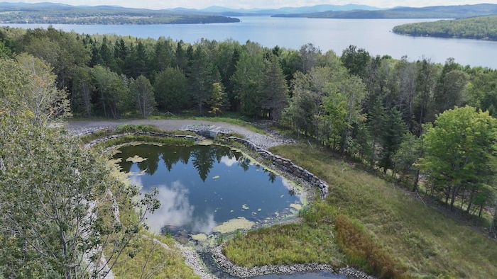 Un bassin de rétention et le lac Mégantic derrière.