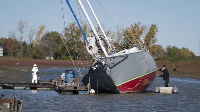 Un bateau incliné dans une marina.