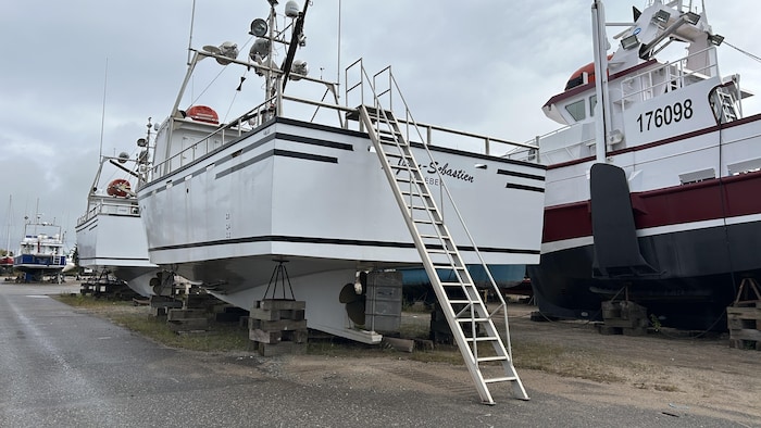 Une échelle mène à un bateau entreposé au parc d'hivernage.
