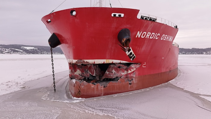 La proue éventrée d'un navire dans une baie glacée.