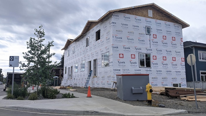 Un édifice en construction recouvert de revêtement Tyvek.