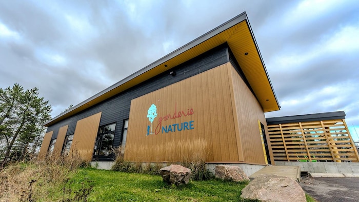 Un bâtiment en bois avec l'inscription garderie Nature.