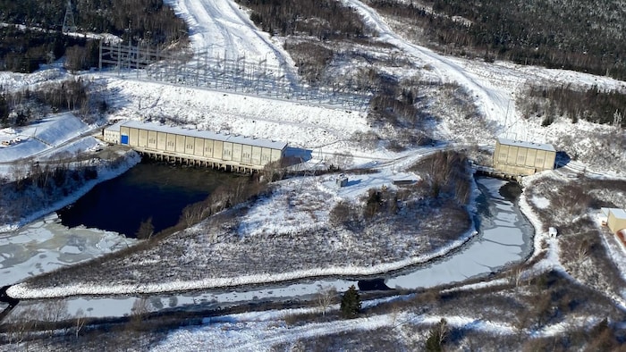 Une photo aérienne de la centrale hydroélectrique et des cours d'eau couverts de glace qui s'y rendent.