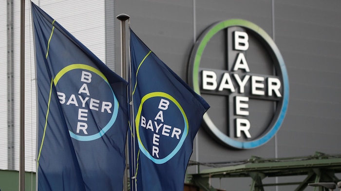 Des drapeaux et un logo géant de l'entreprise devant une de ses usines.