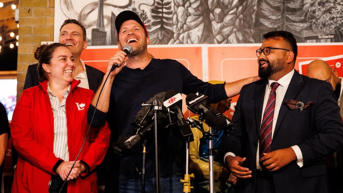 L’ancien député libéral Nate Erskine-Smith (au centre) présente Tanveer Shanhnawaz, député élu de Beaches-East York, lors de la soirée électorale au Stone Lion Pub à Toronto, le lundi 31 août 2026. 