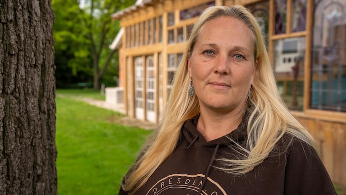 Becky regarde l'objectif devant sa véranda de bois.