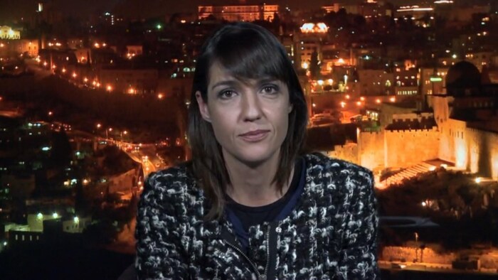 La correspondante de Radio-Canada pour le Moyen-Orient, Marie-Eve Bédard, répond aux questions du public sur Facebook. Derrière elle, la ville de Jérusalem.