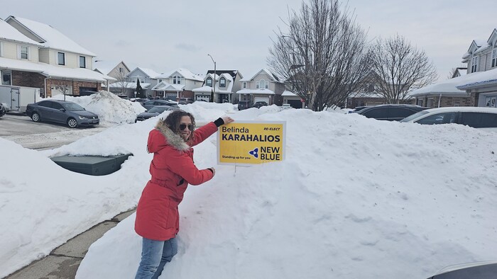 Une femme avec une affiche dans une montagne de neige